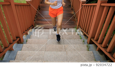 Fitness woman runner running on seaside boardwalk Fitness woman runner running on seaside boardwalk 92034722