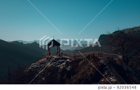 Gazebo with a bell on the background of mountains near the church Gazebo with a bell on the background of mountains near the church 92036548