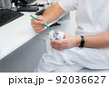 hands of a dentist close-up. dentist with a pencil shows jaw defects on a plaster cast. 92036627