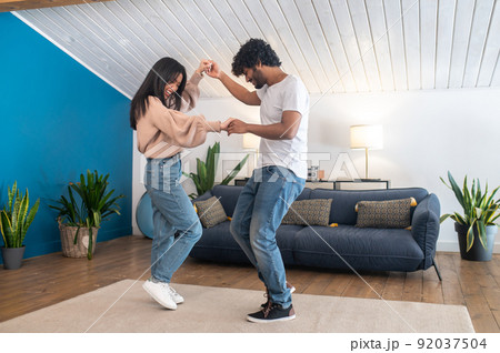 Cute young couple looking happy while dancing 92037504