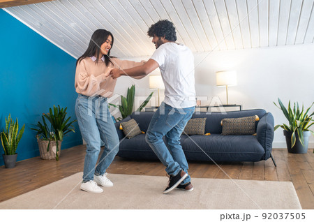 Cute young couple looking happy while dancing 92037505