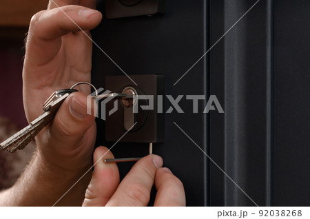 Installation of a door lock, a carpenter installs a door lock in a door, work close-up. Installation of a door lock, a carpenter installs a door lock in a door, work close-up. 92038268