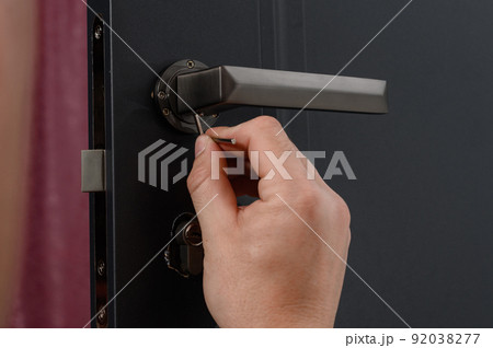 Hex key and installation of door lock and handle, close-up of installation work. 92038277