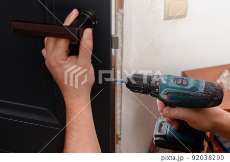 Installation of a door handle on interior doors, carpentry work with doors. Installation of a door handle on interior doors, carpentry work with doors. 92038290