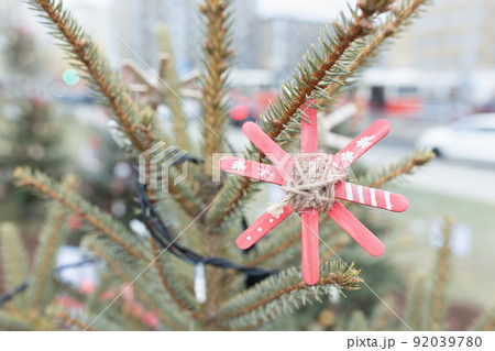 DIY handmade decoration made of craft sticks painted red on Christmas tree DIY handmade decoration made of craft sticks painted red on Christmas tree 92039780