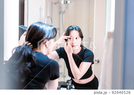 コンタクトレンズを装着する若い女性 92040526