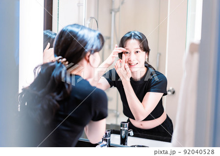 コンタクトレンズを装着する若い女性 コンタクトレンズを装着する若い女性 92040528