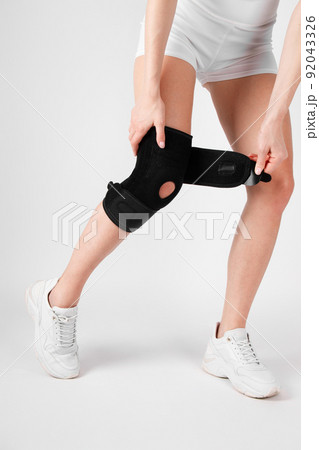 Knee Support Brace on leg isolated on white background. Elastic orthopedic orthosis. Anatomic braces for knee fixation, injuries and pain. Protective knee joint bandage sleeve. Trauma, rehabilitation. Knee Support Brace on leg isolated on white background. Elastic orthopedic orthosis. Anatomic braces for knee fixation, injuries and pain. Protective knee joint bandage sleeve. Trauma, rehabilitation. 92043326