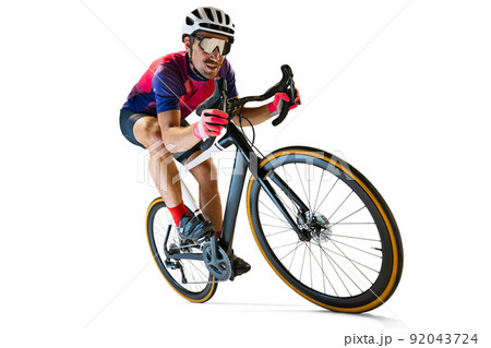 Portrait of man, professional cyclist training, riding isolated over white studio background. Concentration 92043724