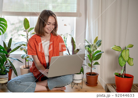 Young female using laptop at home checking email, writing message in social network, searching information. Cozy workplace, remote work learning concept. Young female using laptop at home checking email, writing message in social network, searching information. Cozy workplace, remote work learning concept. 92044633