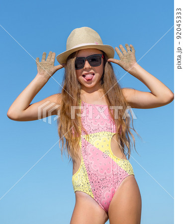 A funny girl in a bathing suit makes funny faces. 92045333