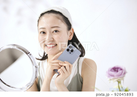 リビングでスマホを見る若い女性 リビングでスマホを見る若い女性 92045893