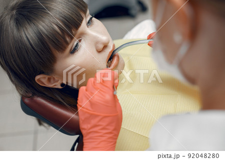 Woman in a dental chair.Girl is examined by a dentist.Beauty treats her teeth 92048280