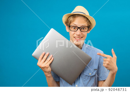 Waist up portrait view of the funny teen person holding laptop in hands. Waist up portrait view of the funny teen person holding laptop in hands. 92048731