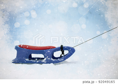 Snow sled on Christmas background.Blue and red plastic sleds Snow sled on Christmas background.Blue and red plastic sleds 92049165
