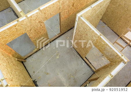 Construction of new and modern modular house. Walls made from composite wooden sip panels with styrofoam insulation inside. Building new frame of energy efficient home concept. Construction of new and modern modular house. Walls made from composite wooden sip panels with styrofoam insulation inside. Building new frame of energy efficient home concept. 92051952