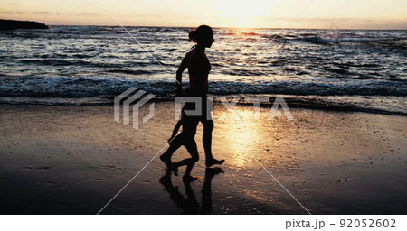 Slow motion of Mother and young girl running on the beach during sunset Slow motion of Mother and young girl running on the beach during sunset 92052602