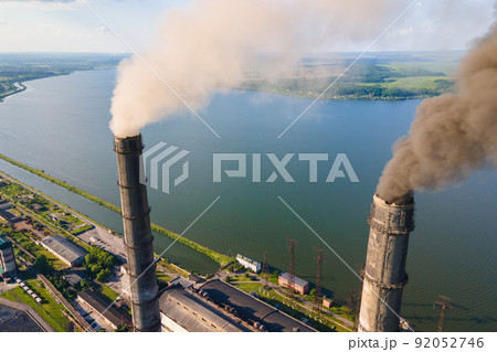 Aerial view of coal power plant high pipes with black smokestack polluting atmosphere. Electricity production with fossil fuel concept. Aerial view of coal power plant high pipes with black smokestack polluting atmosphere. Electricity production with fossil fuel concept. 92052746