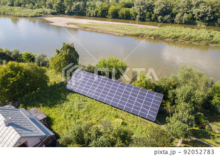 Aerial view of blue photovoltaic solar panels mounted on backyard ground for producing clean ecological electricity. Production of renewable energy concept. 92052783