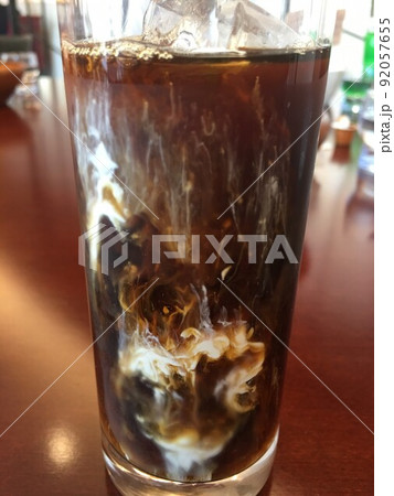 冷たいアイスコーヒーにミルクが混ざる瞬間のグラス 冷たいアイスコーヒーにミルクが混ざる瞬間のグラス 92057655