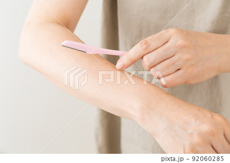 腕の毛を剃るミドル女性 92060285