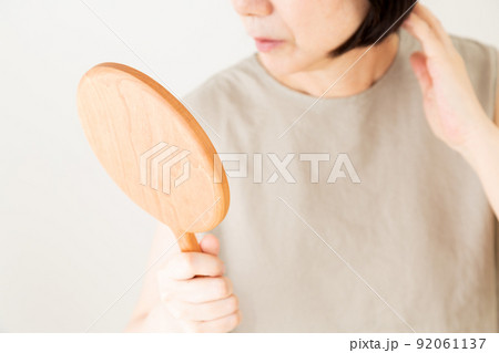 手鏡で顔を見るミドル女性 92061137