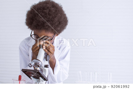 A little african boy using microscope in classroom at school A little african boy using microscope in classroom at school 92061992
