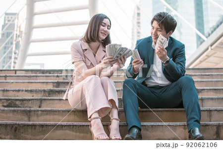 Business man and woman are very happy with a lot of money 92062106
