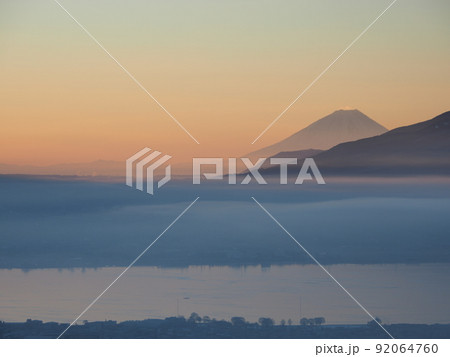 冬の塩嶺御野立公園から薄霧に煙る諏訪盆地と朝焼けの富士山を望む 92064760