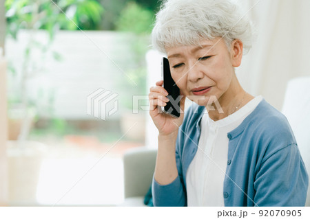 悲しい知らせを受けるシニア女性【スマホ】 悲しい知らせを受けるシニア女性【スマホ】 92070905
