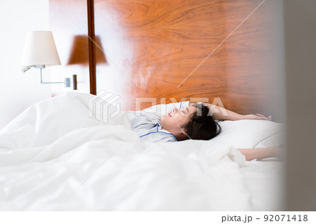 明るい時間にベッドで寝る若い女性 明るい時間にベッドで寝る若い女性 92071418