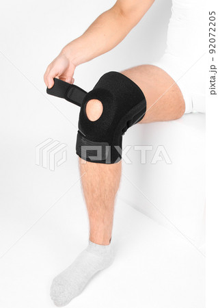 Knee Support Brace on leg isolated on white background. Elastic orthopedic orthosis. Anatomic braces for knee fixation, injuries and pain. Protective knee joint bandage sleeve. Trauma, rehabilitation. Knee Support Brace on leg isolated on white background. Elastic orthopedic orthosis. Anatomic braces for knee fixation, injuries and pain. Protective knee joint bandage sleeve. Trauma, rehabilitation. 92072205