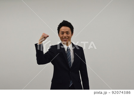 片手でガッツポーズをする若い男性 片手でガッツポーズをする若い男性 92074386