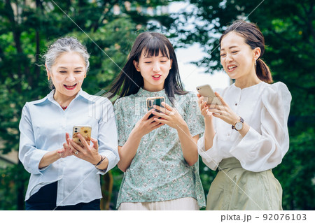 スマートフォンを使うさまざまな世代の女性 92076103