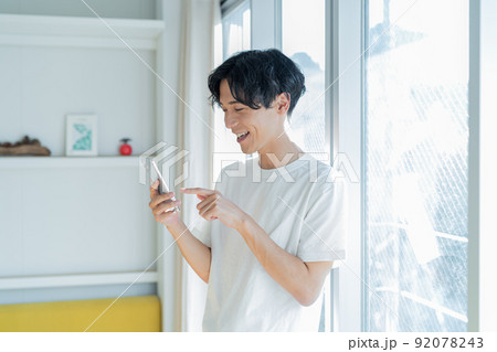 スマホを操作する若い男性 スマホを操作する若い男性 92078243