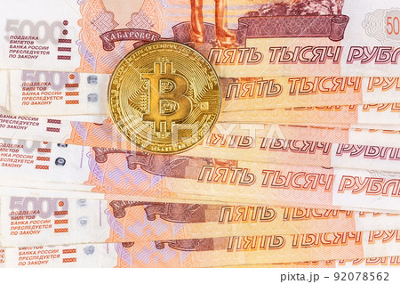 Bitcoin coins on Russian banknotes. 92078562