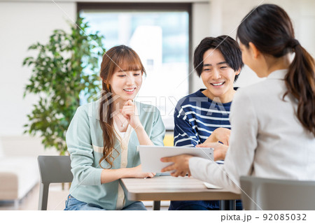 プランナーに相談する若いカップル 92085032