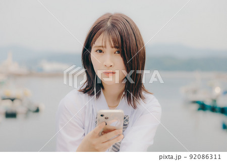 制服姿の女子高生と綺麗な海岸風景 制服姿の女子高生と綺麗な海岸風景 92086311