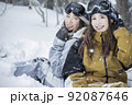 雪の降るスキー場でポーズをするスノボ女子　女子旅 92087646