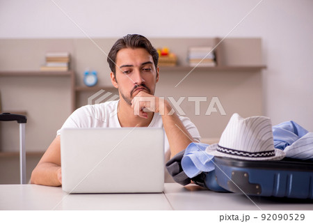 Young man preparing for trip at home 92090529