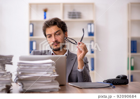 Young male employee unhappy with excessive work in the office 92090684