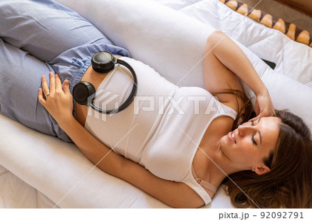 Pregnancy music woman listen. Pregnant woman listening to music. Mother belly listen headphones sound. Concept of pregnancy, maternity, expectation for baby birth. Pregnancy music woman listen. Pregnant woman listening to music. Mother belly listen headphones sound. Concept of pregnancy, maternity, expectation for baby birth. 92092791