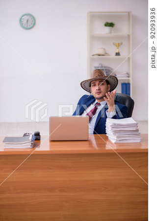 Young cowboy businessman working at workplace Young cowboy businessman working at workplace 92093936