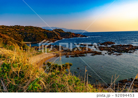 丘から見下ろす岩浜と海岸線の向こうから上る朝日 丘から見下ろす岩浜と海岸線の向こうから上る朝日 92094453
