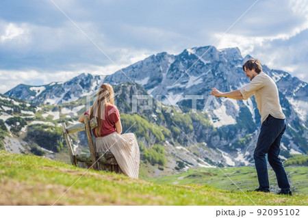 Couple tourists man and woman in Mountain lake landscape on Durmitor mountain in Montenegro beautiful Durmitor National park with lake glacier and reflecting mountain 92095102