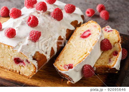 Raspberry bread cake with white icing close-up on a wooden board. horizontal 92095646