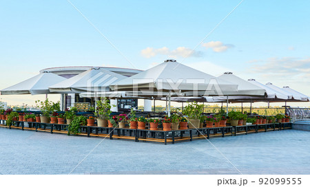 Summer open-air cafe with umbrellas and flowers without people 92099555