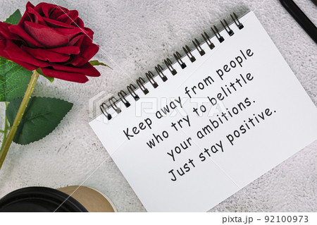 Motivational quote on a note book with roses on a desk. Motivational quote on a note book with roses on a desk. 92100973
