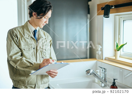 水回りをチェックする作業着姿の若い男性 92102170