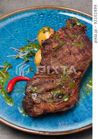 marbled beef steak with new potatoes and green butter marbled beef steak with new potatoes and green butter 92102899